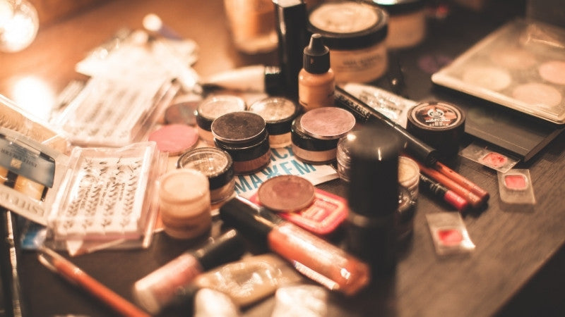 Cluttered makeup products scattered across a vanity table.